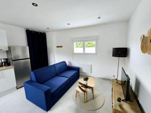 a living room with a blue couch and a table at Maison 4 personnes - Louargat in Louargat