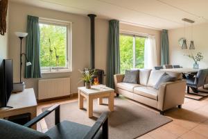 a living room with a couch and a table at Summio Vakantiepark Het Drentse Wold in Hoogersmilde