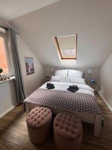 a bedroom with a large bed with two ottomans at Altstadtferienwohnung Stade-Cozy Home -ein zweites Zuhause finden in Stade
