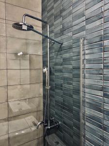 a shower in a bathroom with green tiles at Casa Akrolithos in Keramotí +15 photos