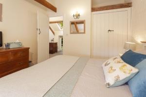 East Harwood Farm Cottage في مينهيد: غرفة نوم مع سرير وخزانة