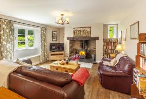 a living room with a couch and a fireplace at Stockham Farm, Dulverton in Dulverton