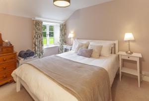 a bedroom with a large white bed and a window at Stockham Farm, Dulverton in Dulverton