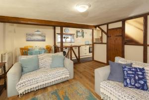 a living room with two couches and a kitchen at Cuain Cottage, Watchet in Watchet +15 photos