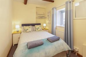 a bedroom with a bed with two pillows on it at Cuain Cottage, Watchet in Watchet