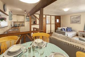 a dining room with a table and chairs and a kitchen at Cuain Cottage, Watchet in Watchet