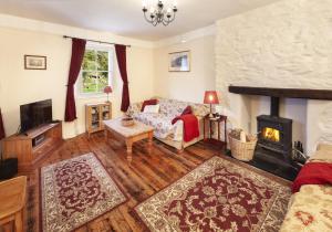 a living room with a couch and a fireplace at Lorna Doone Cottage, Lynmouth in Lynmouth