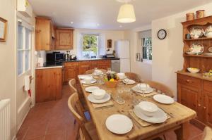 a kitchen and dining room with a wooden table and chairs at Lorna Doone Cottage, Lynmouth in Lynmouth