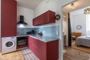 a kitchen with red cabinets and a washer and dryer at Repaire du Bagnérais in Bagnères-de-Bigorre +10 photos
