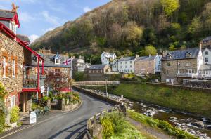 a winding street in a small town with houses at Lorna Doone Cottage, Lynmouth in Lynmouth