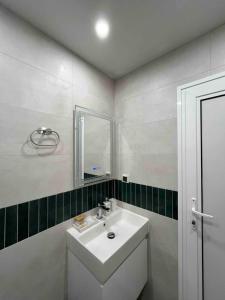 a white bathroom with a sink and a mirror at Sea Treasure in Varna City +20 photos