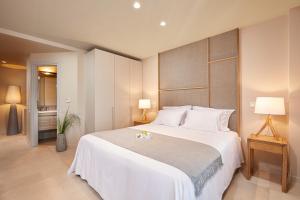 1 dormitorio con 1 cama blanca grande y 2 lámparas en CW Athens Riviera Suite, en Atenas