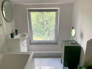 a bathroom with a tub and a sink and a window at Willa Pod Dębem in Koczarki +47 photos