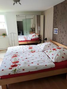 a bedroom with two beds with red flowers on them at Ferienwohnung Südheide in Beedenbostel