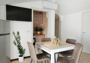 a dining room with a white table and chairs at Holihome Gorycia House FRN in Alba Adriatica