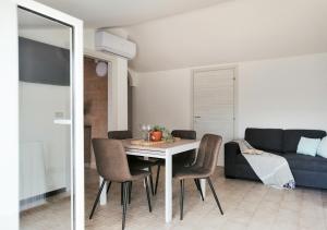a dining room with a table and chairs and a couch at Holihome Gorycia House FRN in Alba Adriatica +14 photos