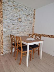 a table and chairs in a room with a brick wall at Familienfreundliche Studio 42m2 mit gratis Parking und WiFI nahe Sportaren und Torrentbahn in Leukerbad
