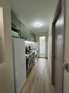 a kitchen with white appliances and a wooden floor at Sea Treasure in Varna City