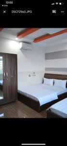 a bedroom with two beds and a wooden cabinet at Khách sạn Mỹ Uyên in Thôn Mỹ Phước