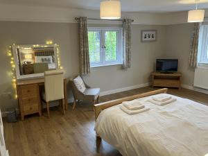 a bedroom with a bed and a desk and a computer at Barn Cottage, Minehead in Minehead