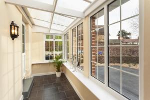 a conservatory with windows and a window seat at Barn Cottage, Minehead in Minehead