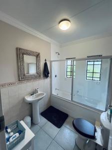 un baño con ducha y lavabo en Cape-Dutch 2 Bedroom Home, en Tierpoort
