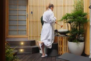 a woman in a robe standing on a patio at Hotel Litteraire Le Swann, BW Premier Collection in Paris
