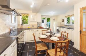 a kitchen with a table and chairs in a kitchen at Jasmine Cottage Porlock in Porlock