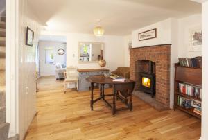 a living room with a table and a fireplace at Jasmine Cottage Porlock in Porlock