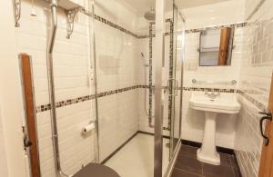 a white bathroom with a sink and a shower at Jasmine Cottage Porlock in Porlock +22 photos