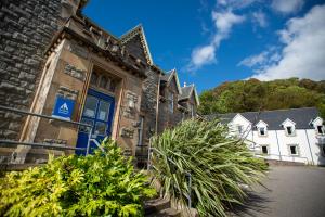 un viejo edificio con plantas delante de él en Oban Youth Hostel, en Oban