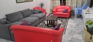 a living room with a couch and two red chairs at The CRISNA'S Apartment in Port Dickson