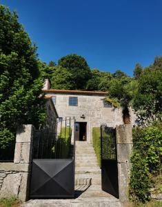 una entrada a una casa de piedra con una puerta negra en Arrueiro, en Arrueiro