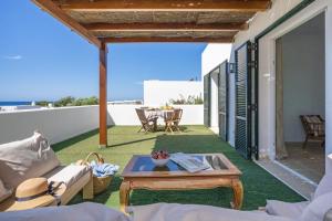 a living room with a table on a patio at Villa Pepponi in Sant Lluis