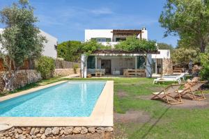 a villa with a swimming pool and a house at Villa Pepponi in Sant Lluis