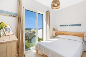 a bedroom with a bed and a large window at Villa Pepponi in Sant Lluis