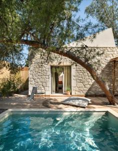 einen Pool vor einem Steinhaus in der Unterkunft Ergon Beach House Nikiti in Nikiti