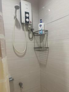 a shower in a bathroom with a hair dryer at Puerto Princesa City Palawan Harmony Inn in Puerto Princesa City