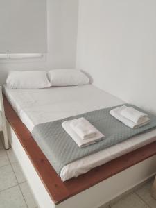 a large bed with white sheets and pillows on it at ANATOLI 1 BEACH APARTMET Ligaria in Lygaria