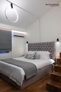 a bedroom with a large bed with a large headboard at Asteroskoni Luxury Suites in Nafplio