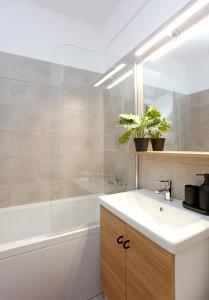 a bathroom with a white sink and a bath tub at Modern & Cozy Studio with Balcony in Roşu