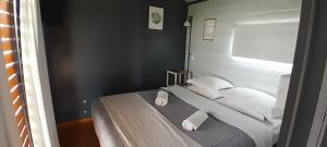 una camera da letto con letto, lenzuola e cuscini bianchi di Cantal Tiny house a Salta