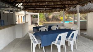 a table and chairs with a blue table and a pool at Coco Beach in El Paredón Buena Vista