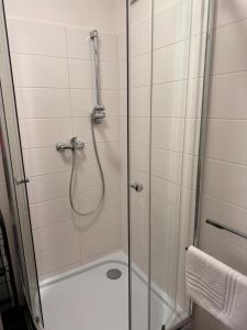 La salle de bains est pourvue d'une douche avec une porte en verre. dans l'établissement Apartmán RUŽA14, à Ružomberok