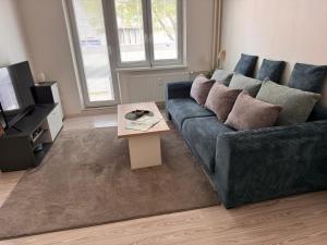 a living room with a blue couch and a coffee table at Apartmán RUŽA14 in Ružomberok