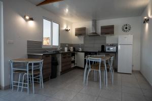 a kitchen with two tables and a refrigerator at Résidence ATLAS in Saint-Laurent du Maroni