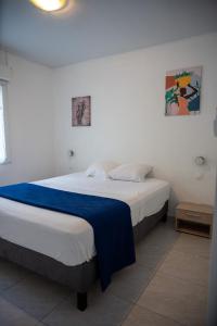a bedroom with a bed with a blue blanket on it at Résidence ATLAS in Saint-Laurent du Maroni