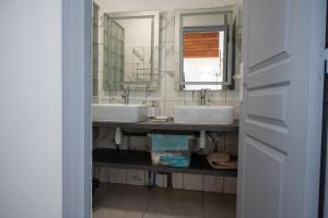 a bathroom with two sinks and a mirror at Résidence ATLAS in Saint-Laurent du Maroni +51 photos