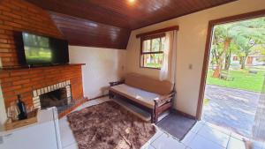 uma sala de estar com lareira e uma televisão de ecrã plano em Villa Chalés Gramado - OH HOTÉIS em Gramado