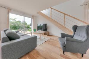 a living room with two couches and a tv at Maison pour 8 - 300m de la plage du Rouvran in Le Tour-du-Parc